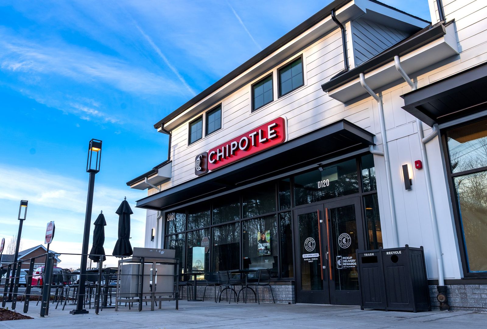 Chipotle restaurant storefront with black metal awning and patio seating by Manchester Awning