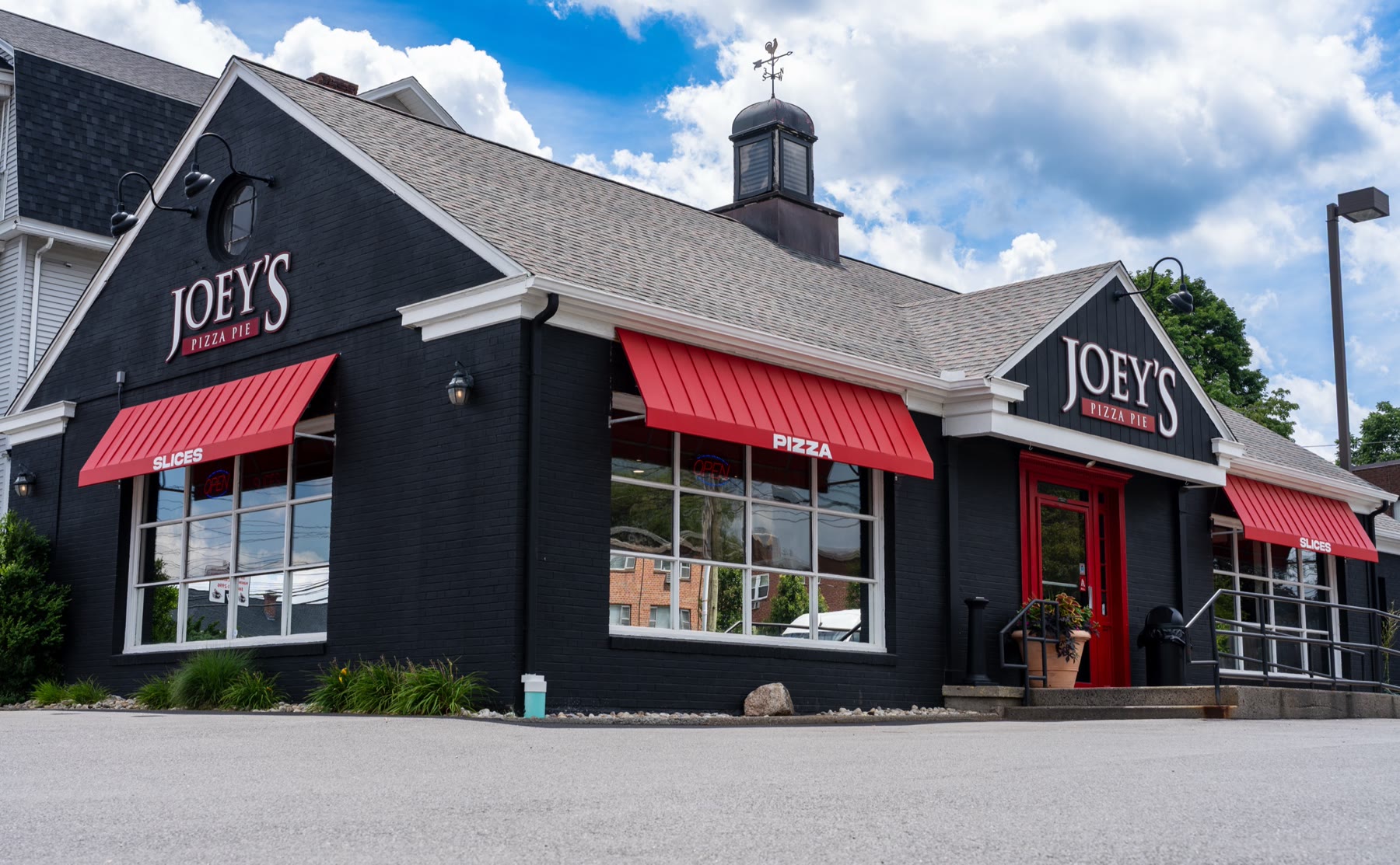 Angled street view of the deep red standing-seam awnings on Joey’s Pizza Pie in West Hartford, CT, showing the crisp vertical ribs