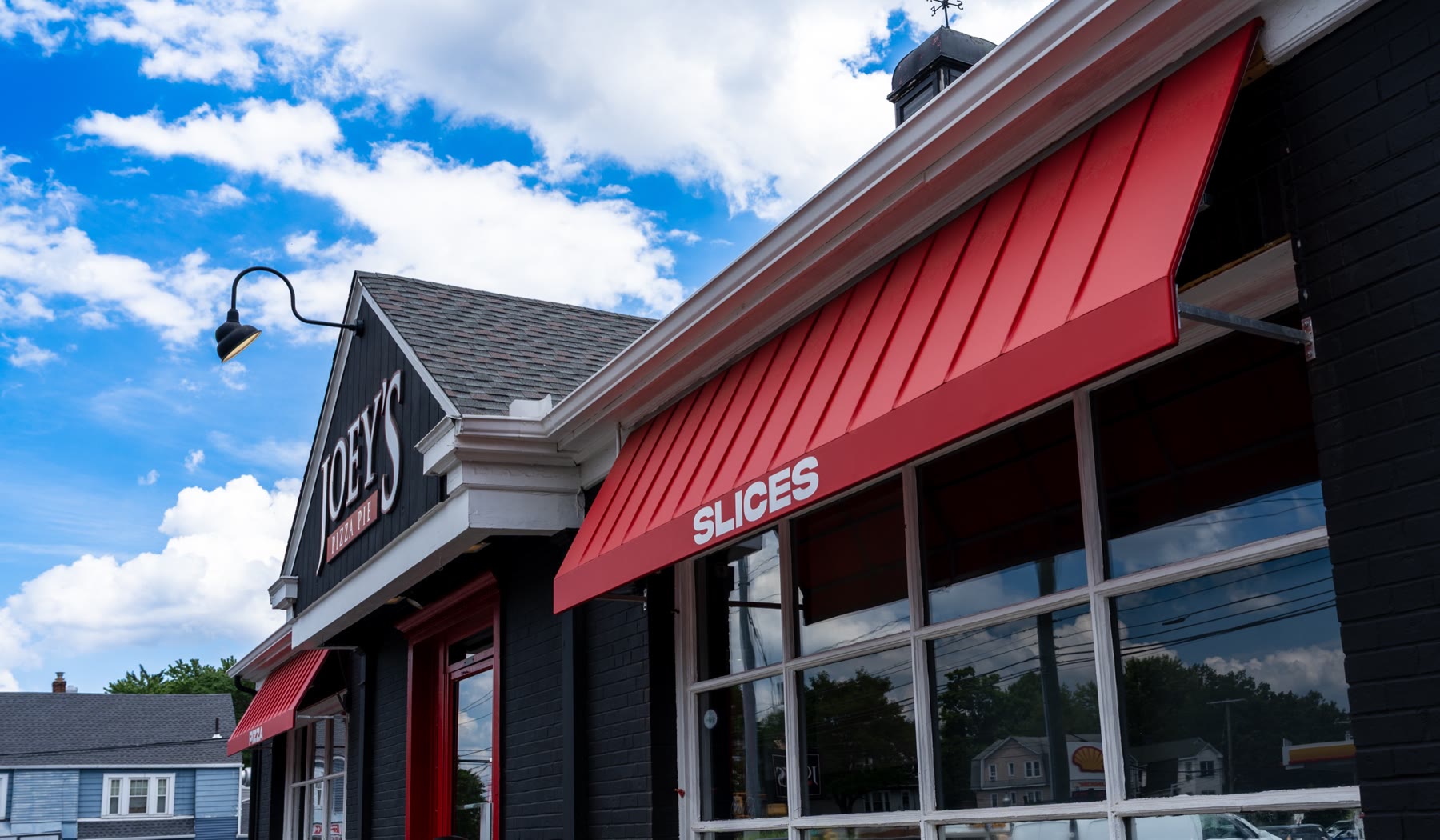Close-up of crisp vertical standing-seam ribs on a red fabric awning by Manchester Awning