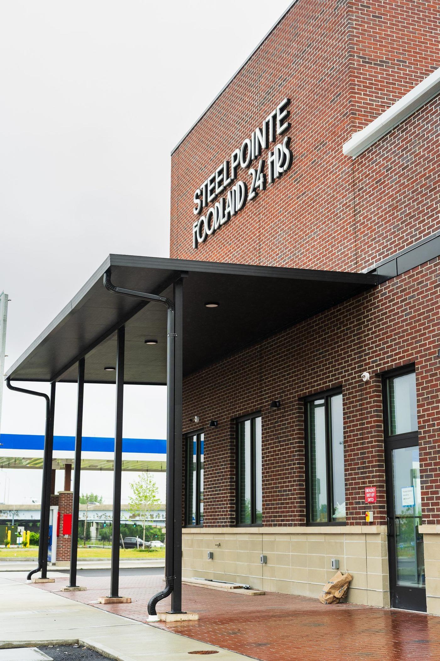Long covered walkway canopy on steel columns at Steelpointe Foodland by Manchester Awning