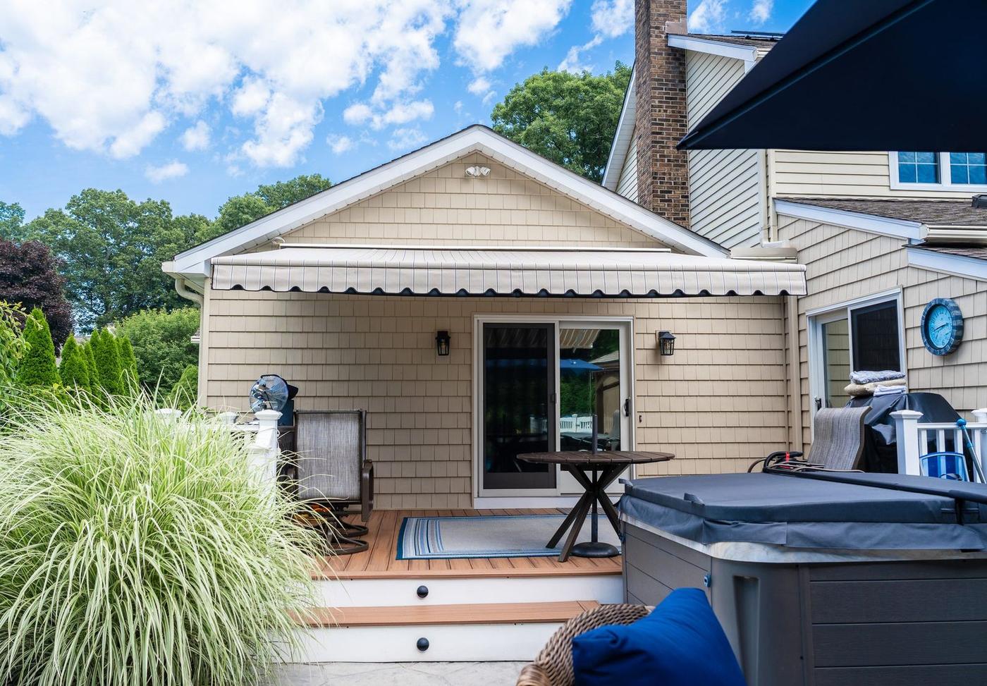 Retractable awning shading a Connecticut backyard deck and hot tub by Manchester Awning