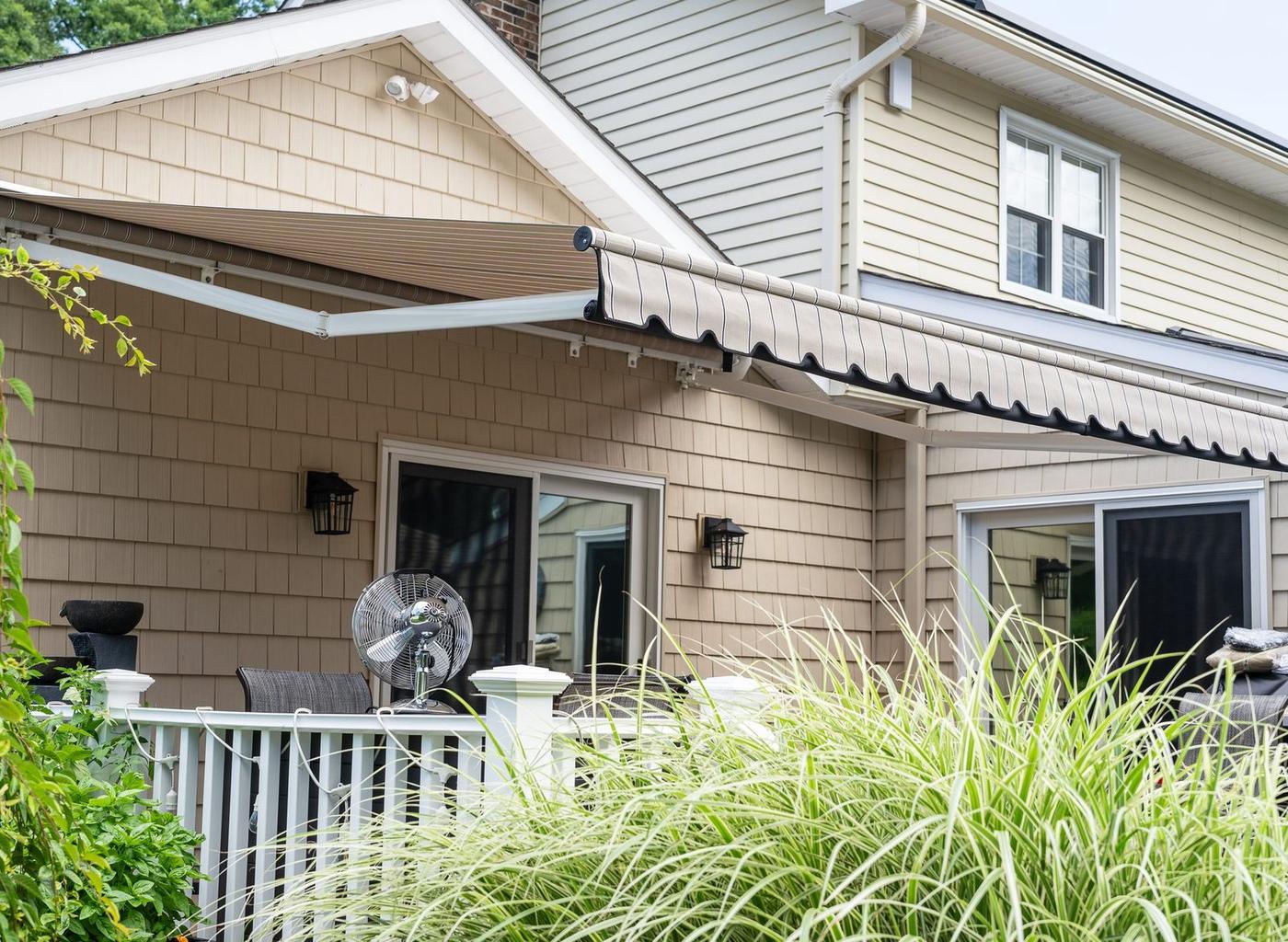 Striped retractable awning extended over a Connecticut home deck by Manchester Awning