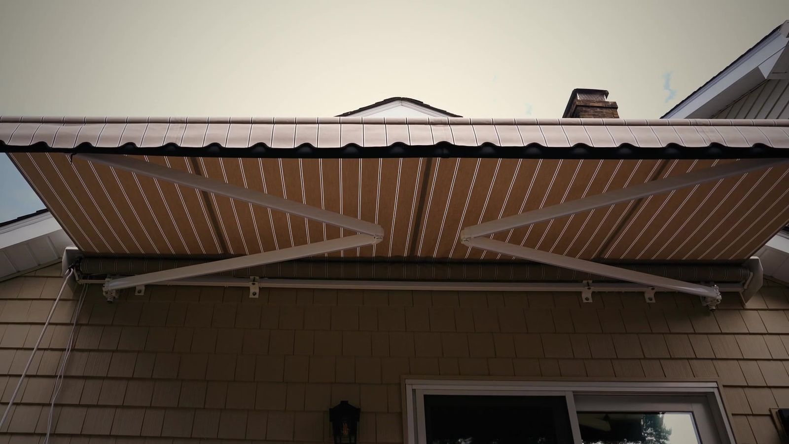 Legend lateral-arm retractable awning extended over a Connecticut home, installed by Manchester Awning