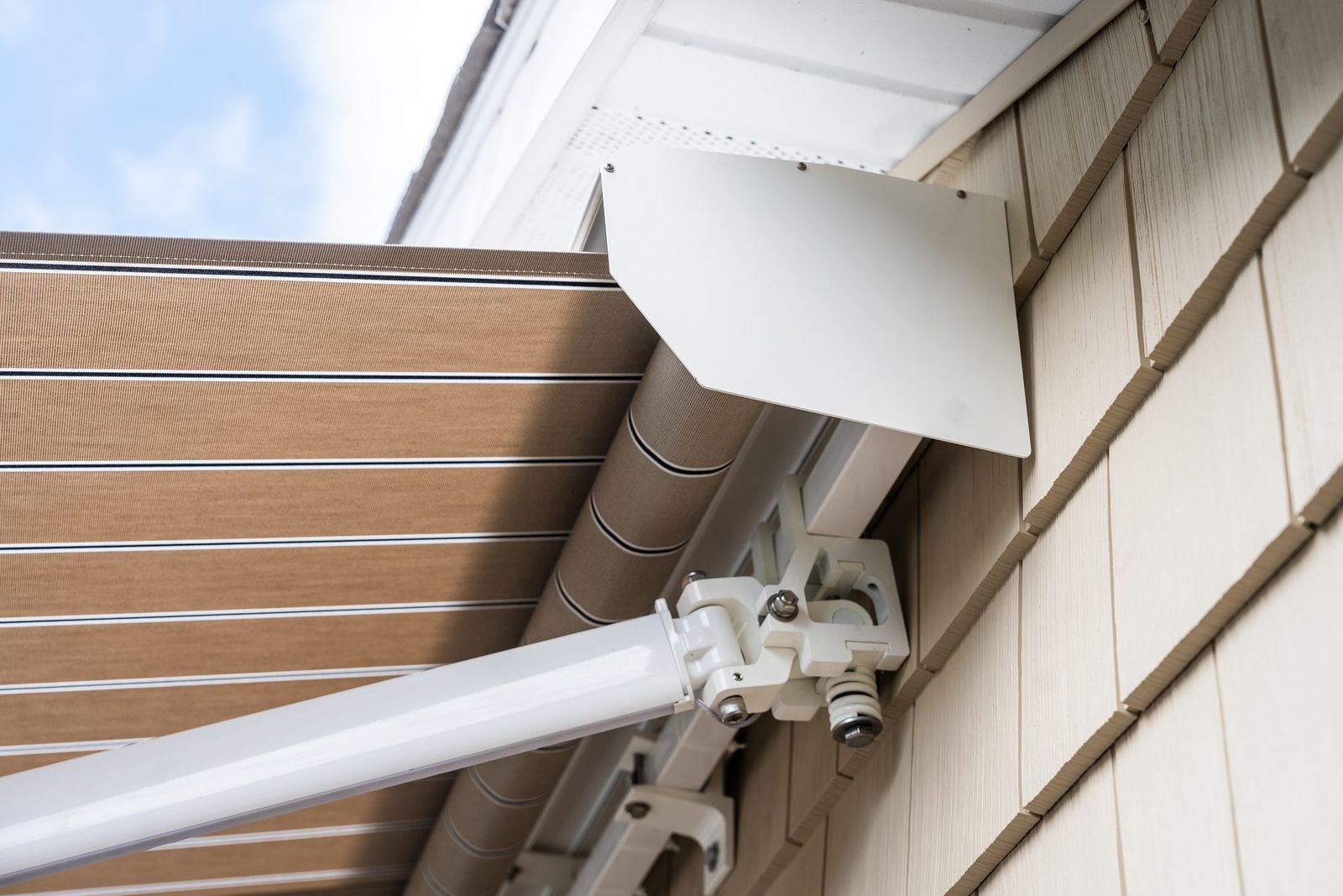 Somfy sun sensor mounted beside a retractable awning arm on a Connecticut home by Manchester Awning